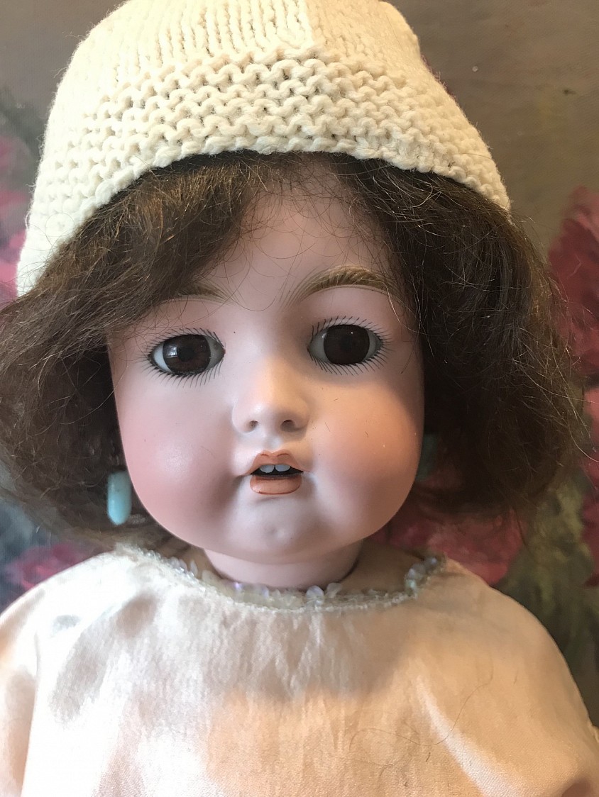 PRETTY IN PEACH!  Simon Halbig 1299 with rare working MAMA crier ball jointed body stamped in red Heinrich Handwerck Germany 2 1/2. Her red outlined fingers and toes are still brightly there. She stands 20 1/2” tall with molded brows, brown sleep eyes, pierced ears with Jumeau blue antique earrings and a cupid’s bow open mouth with 2 adorable upper teeth. Her antique  brown  wig suits her well. She wears a breathtaking pink antique silk French corset with lace trims, pale peach openwork socks, brown antique German shoes marked 9 on sole, lovely cream pantaloons with a stunning Depression era peach silk dress with crystal sequins for a pop of flare! Her peach knit bonnet is also antique. She is a desirable mold who comes ready to display. Her eyes sleep perfectly and she is free of hairlines. ~ $ 695 postage paid within the US. International buyer please contact me for  actual costs. layaway is available
